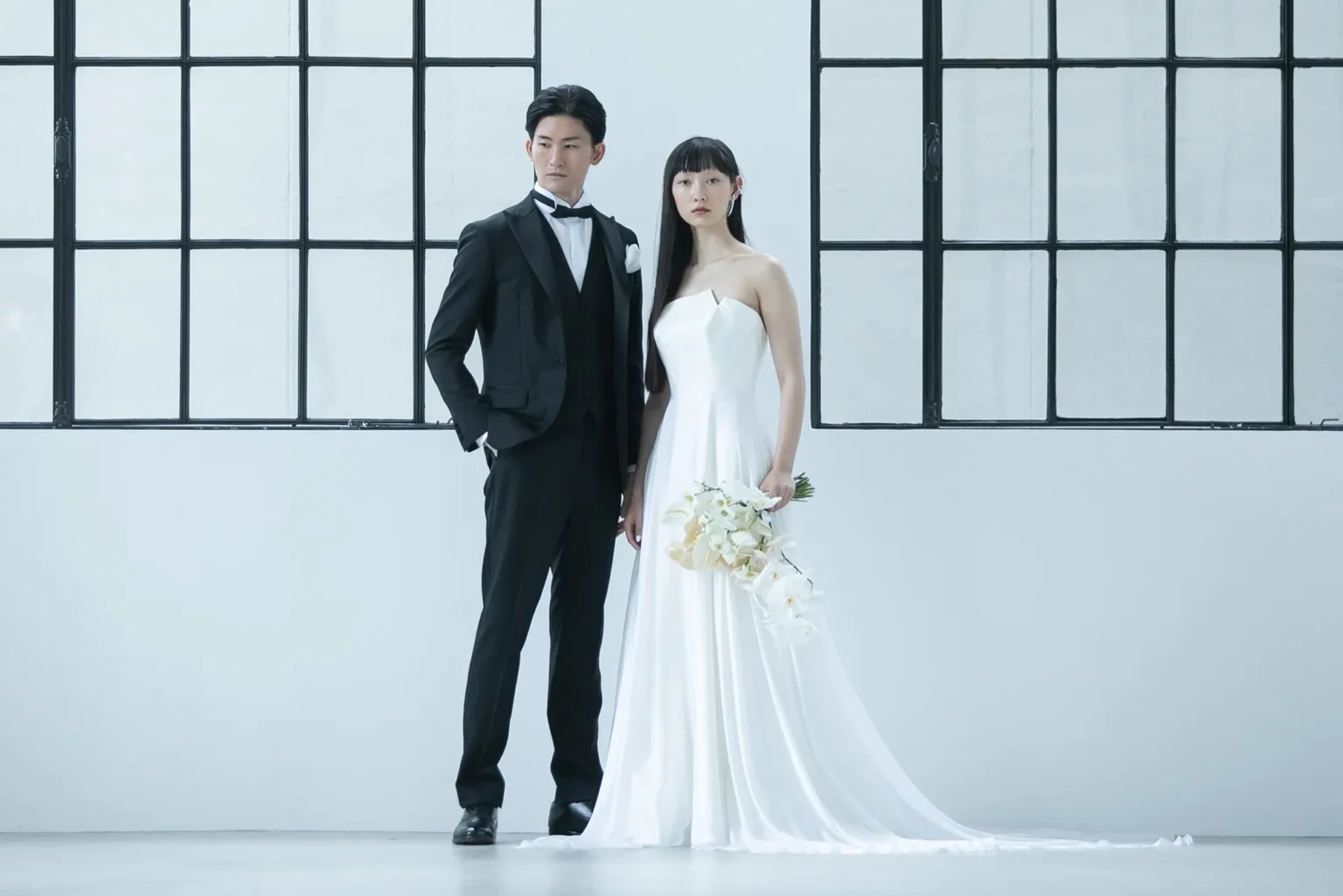 最上級のシルクサテンで作られたスレンダードレスを着た花嫁とタキシードを着た花婿