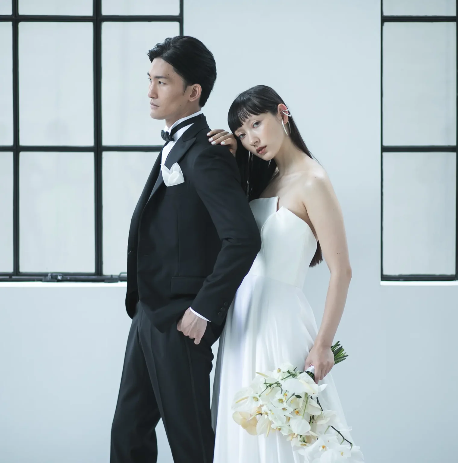 最上級のシルクサテンで作られたスレンダードレスを着た花嫁とタキシードを着た花婿