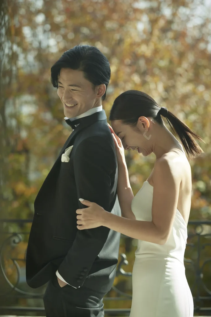 紅葉の見える羊羹のベランダでウェディングフォトを撮影するカップル