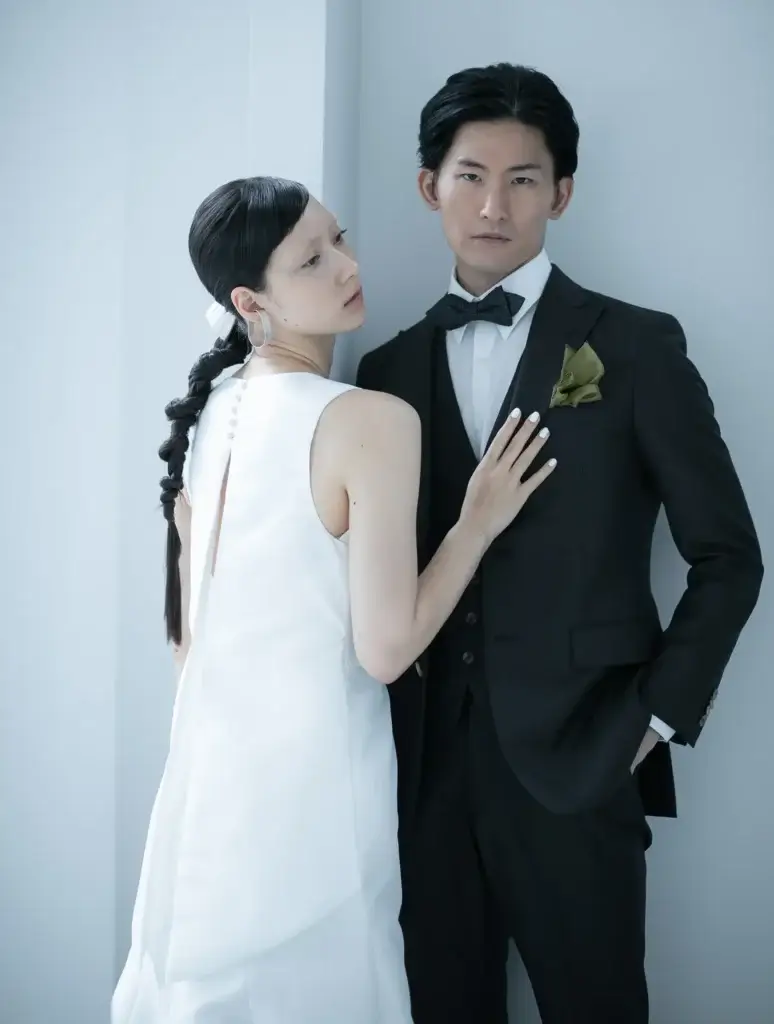 ブラックのタキシード姿の新郎とシンプルで美しいウェディングドレス姿の新婦のスタイリッシュなウェディングフォト