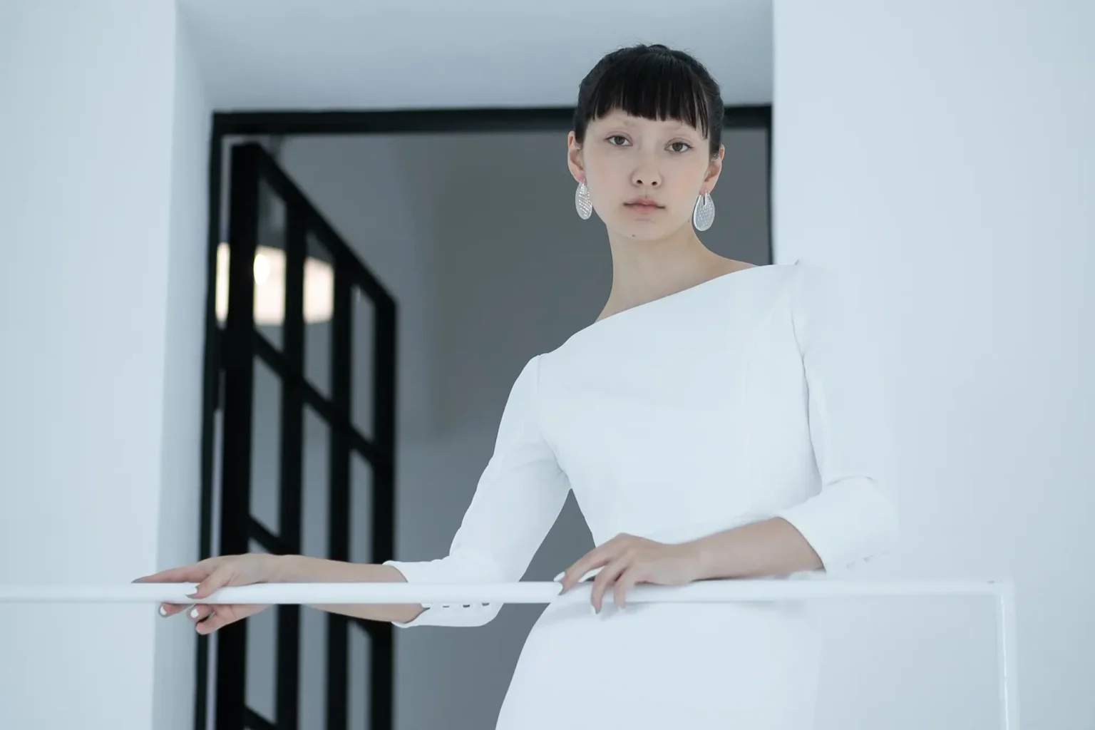 ボートネックで長袖のマーメイドシルエットのウェディングドレスを着た女性