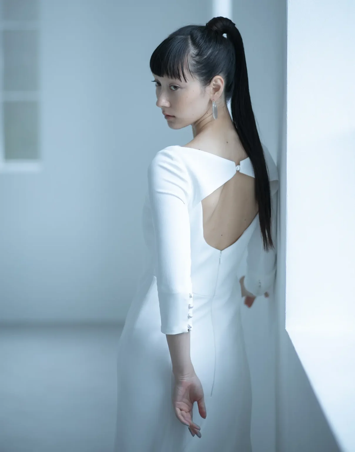 背中の開きが特徴のウェディングドレスをモードに着こなした女性