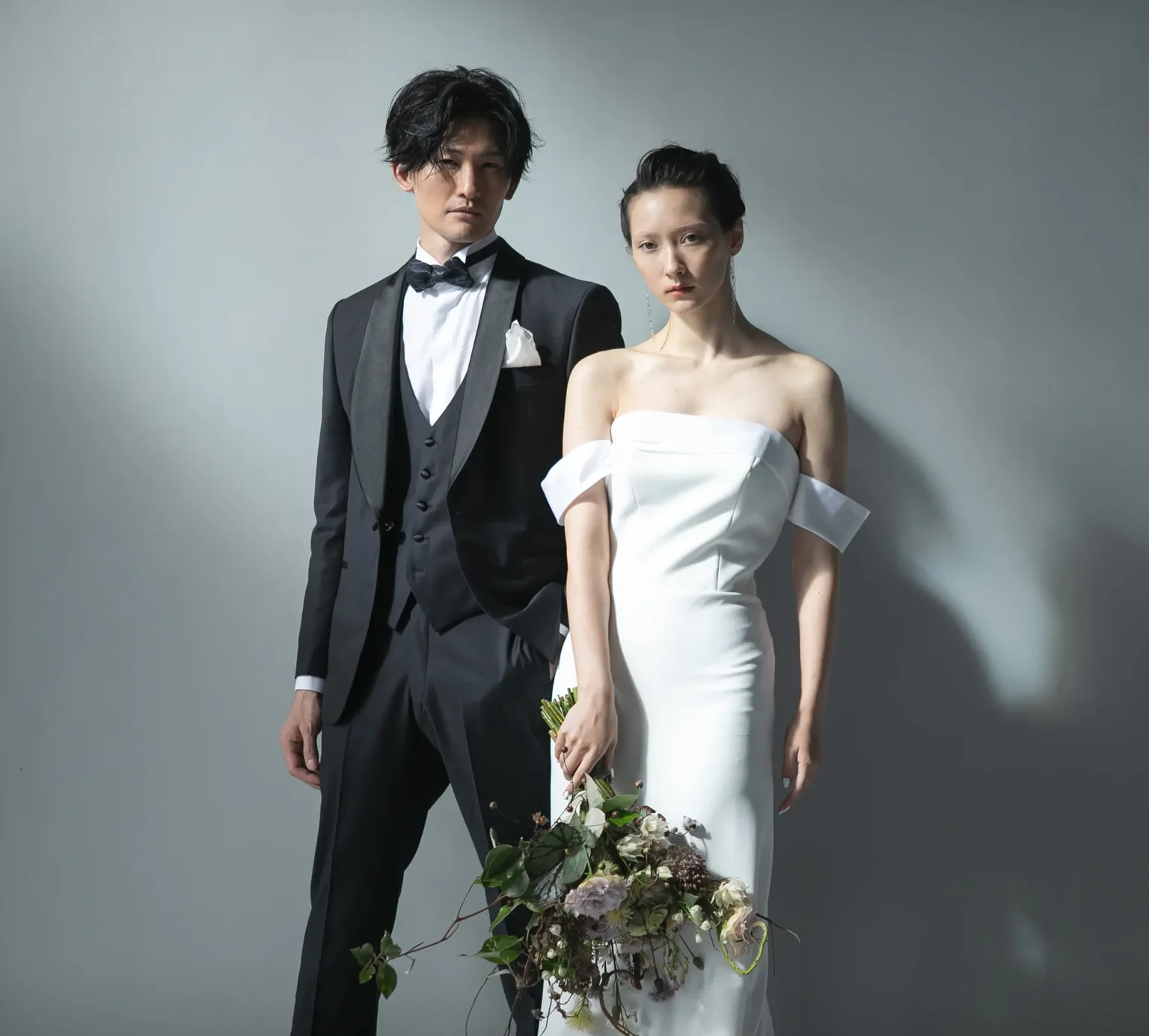 優美さとスタイリッシュさを併せ持つマーメイドラインのウェディングドレスを着た新婦とタキシード姿の新郎