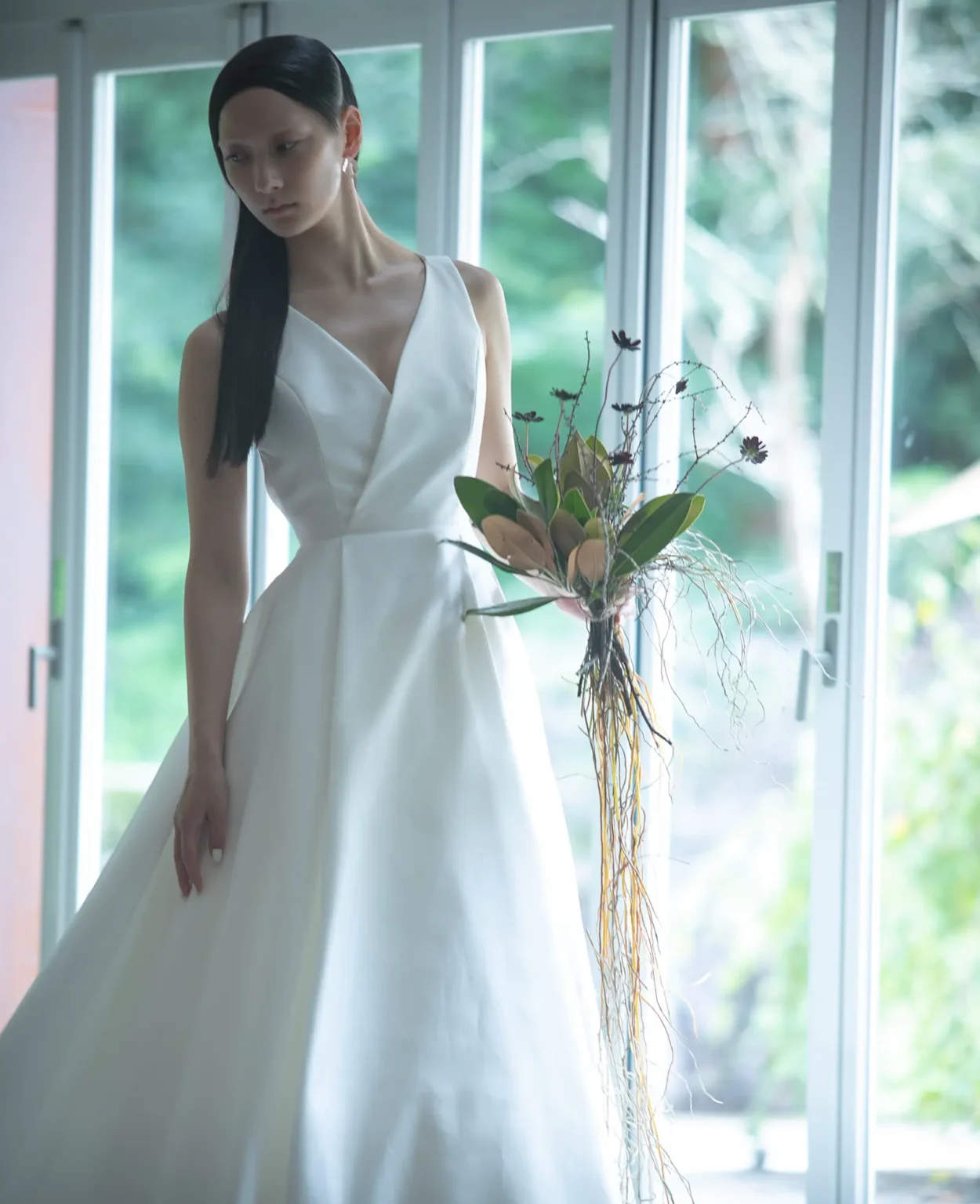 ⾜元にかけて流れるようなAラインを描き、⼥性らしさとハンサムさを表現するドレス