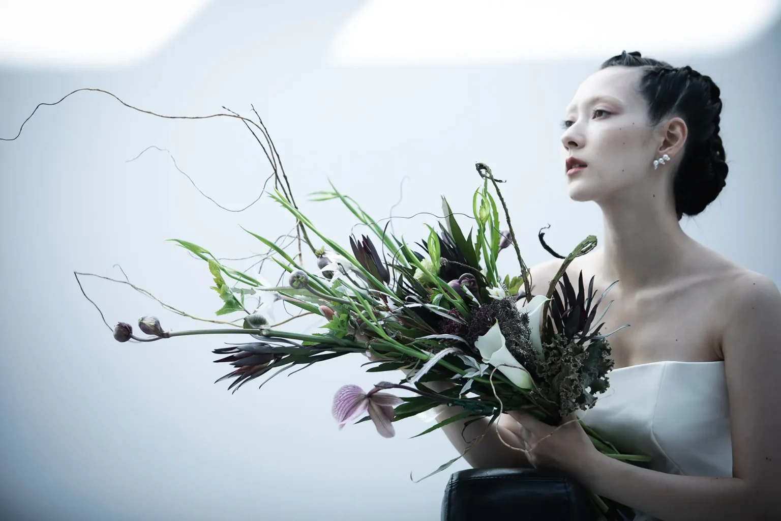 大ぶりのブーケを持ったウェディングドレス姿の女性