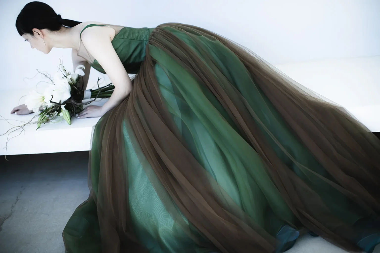 動くたびに色の濃淡が生まれ、一瞬ずつ新たな表情を見せる、グリーンにブラウンのチュールを重ねたカラードレス