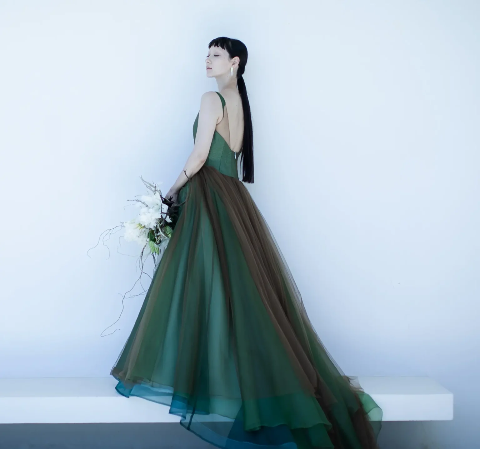 動くたびに色の濃淡が生まれ、一瞬ずつ新たな表情を見せる、グリーンにブラウンのチュールを重ねたカラードレス
