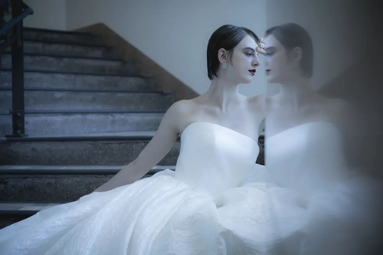 ウェディングドレスを着た女性が階段に座っている様子