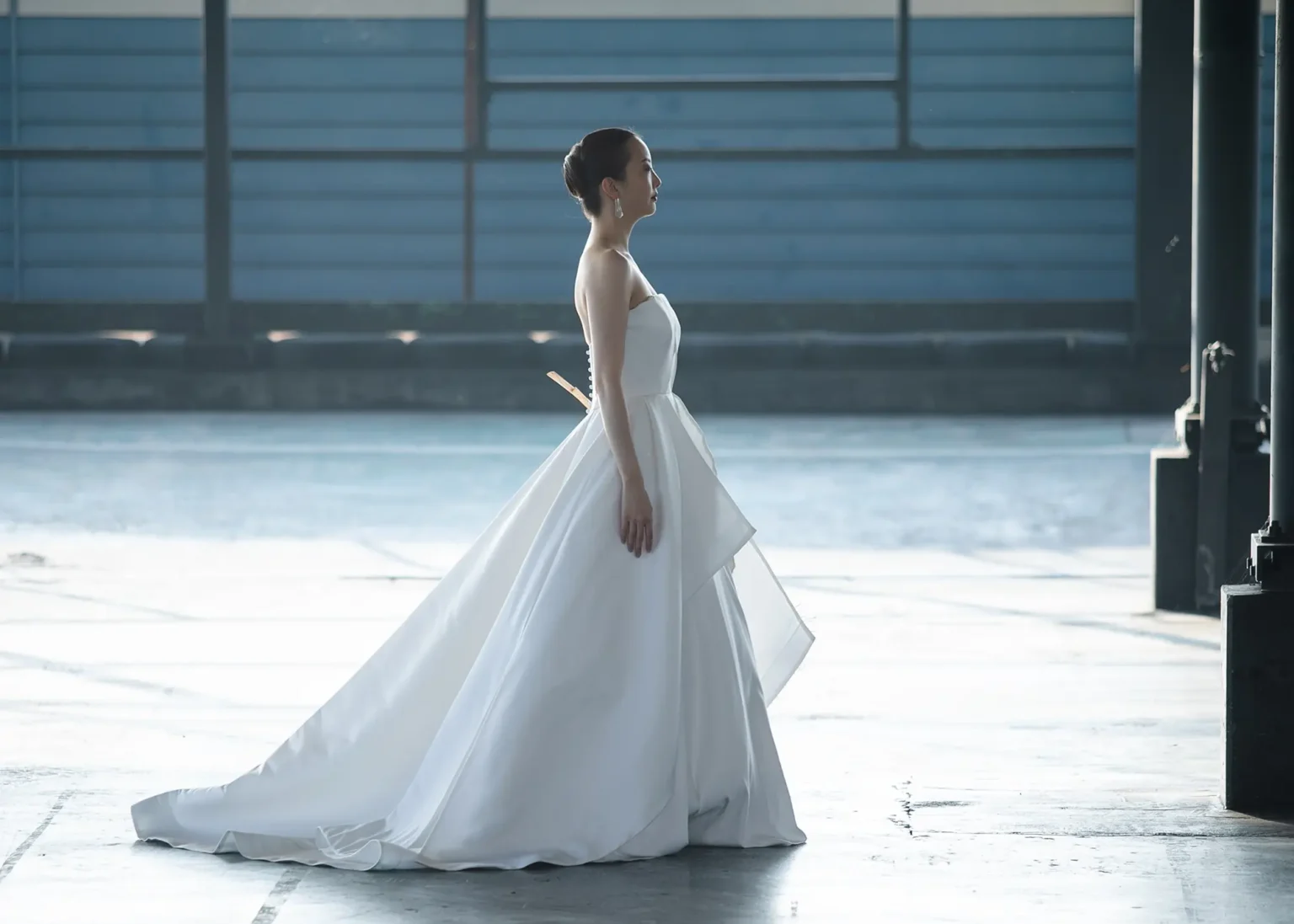 nae. ATELIERナエアトリエのシンプルな Aラインのウェディングドレスを着た女性のサイドの写真