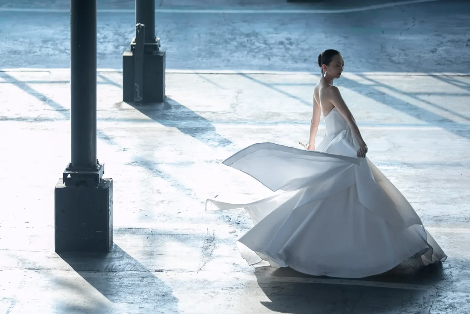 nae. ATELIERナエアトリエのシンプルな Aラインのウェディングドレスをはためかせた女性の写真
