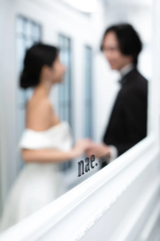 白いインテリアのアパートメントでフォトウェディングをするカップル